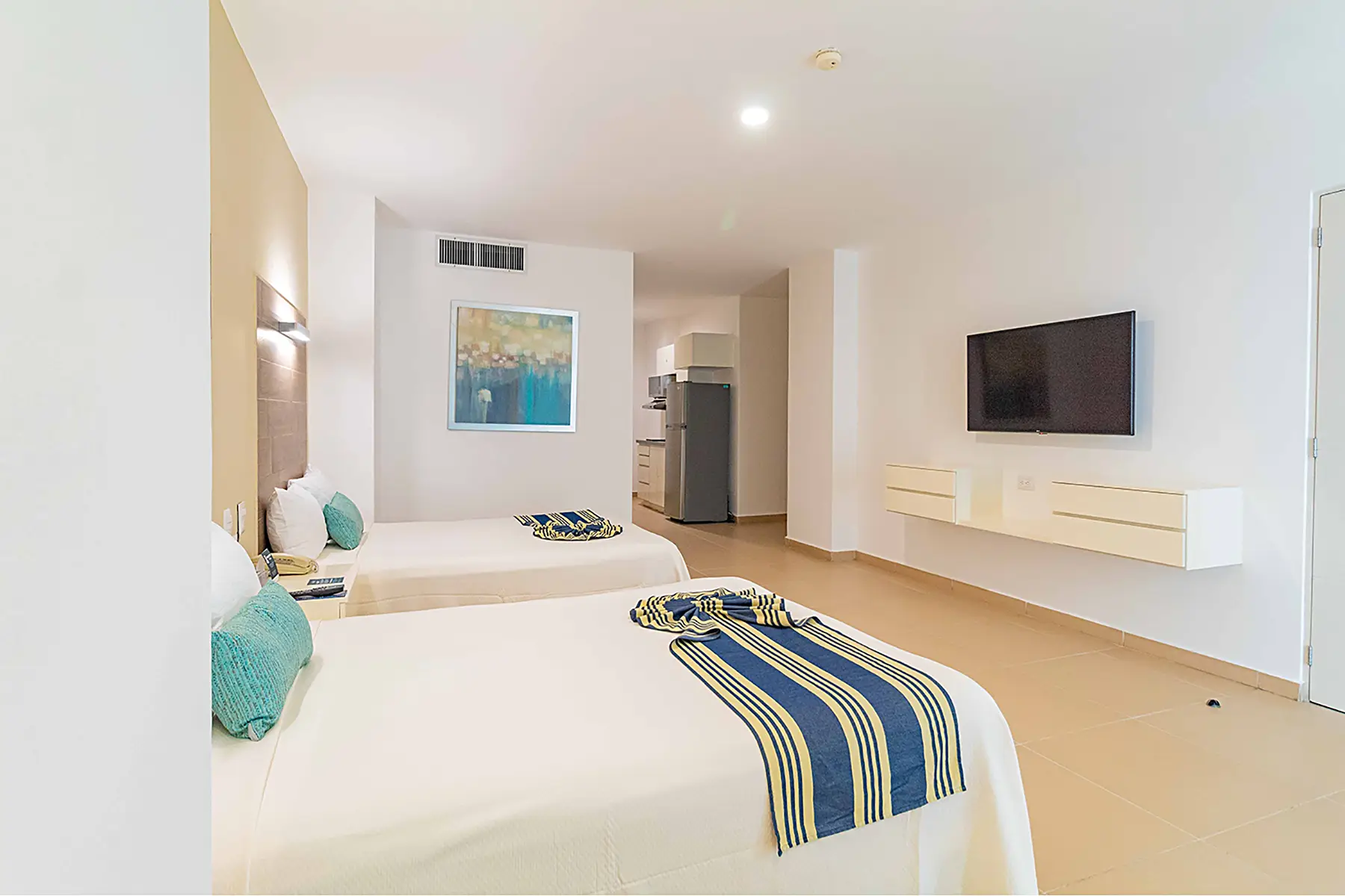 Habitación junior suite, dos camas matrimoniales, aire acondicionado, tv, mobiliario, cocineta, cuadro decorativo, luminaria, hotel pacific palace